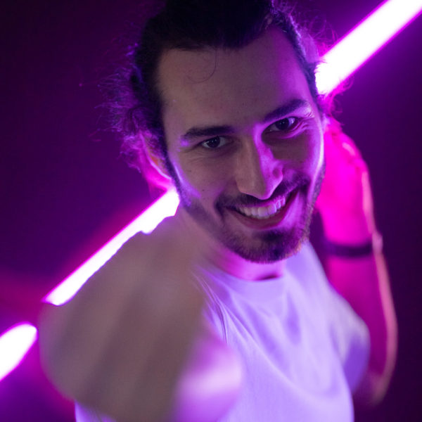 Portrait d'un membre de l'équipe We Feel Good avec un fond violet et néon