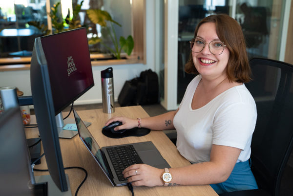 Une collaboratrice sourit a son bureau