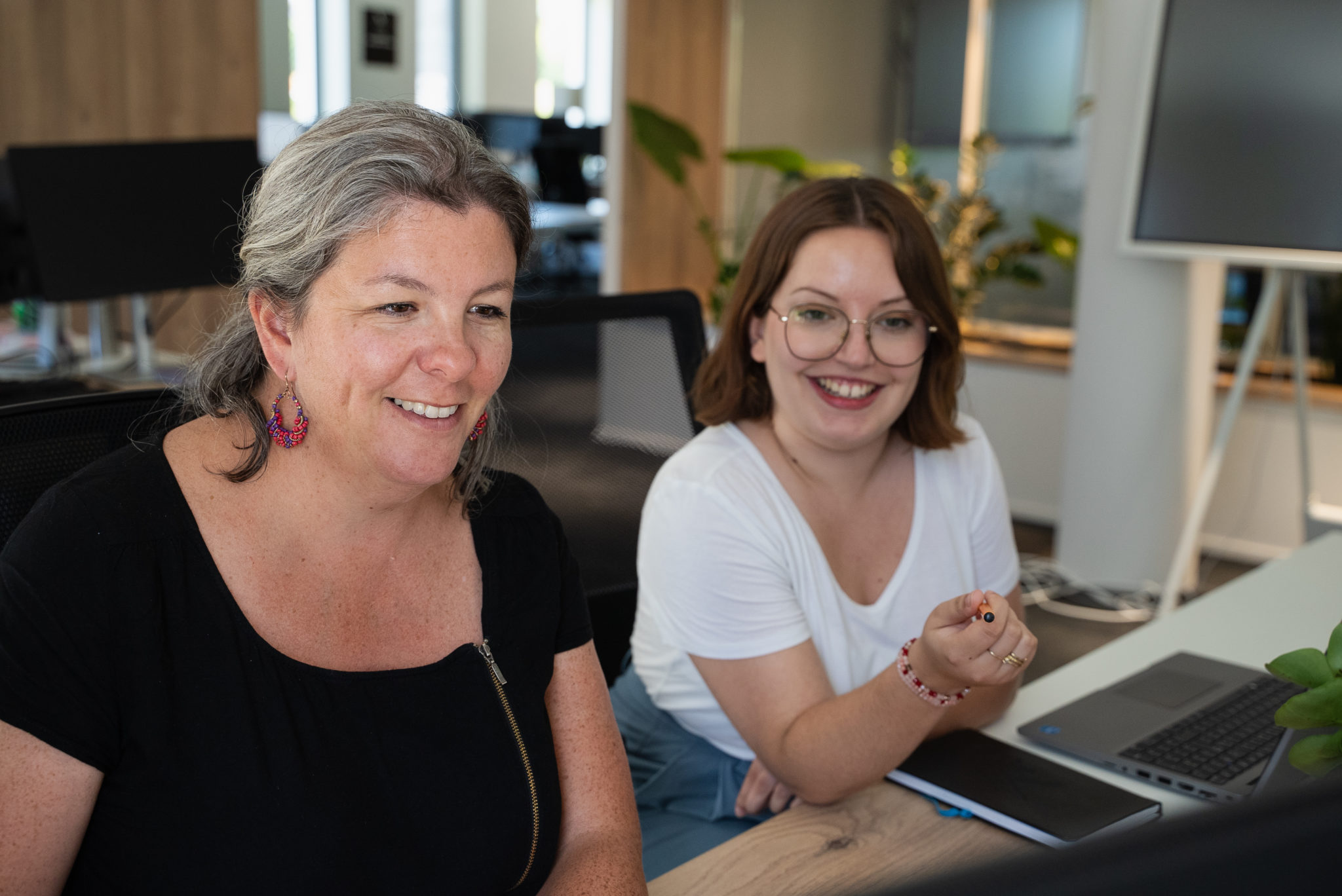 Deux collaboratrices échangent sur un projet d'audit RH de marque employeur aux bureaux de l'agence We Feel Good