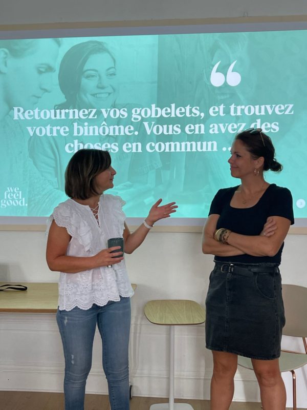 Deux participantes de la société Grand Lyon échangent pendant un atelier organisé par l'agence We Feel Good