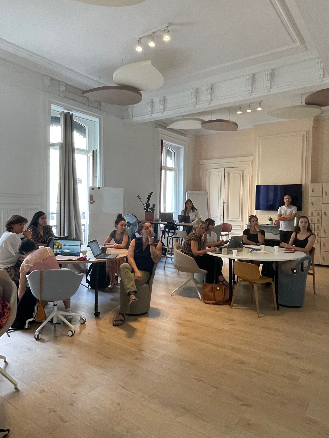 Groupe de personnes assises à des tables rondes pendant un atelier sur la marque employeur