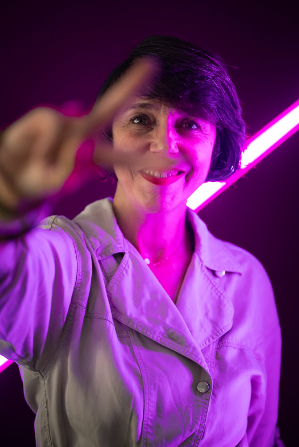 Portrait d'un membre de l'équipe We Feel Good avec un fond violet et néon
