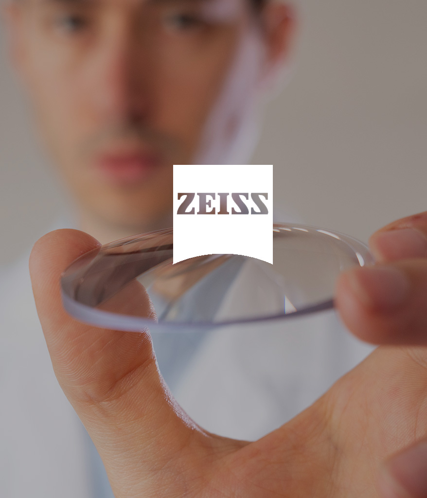 Un homme tient un verre de lunette de la marque Zeiss, un client We Feel Good