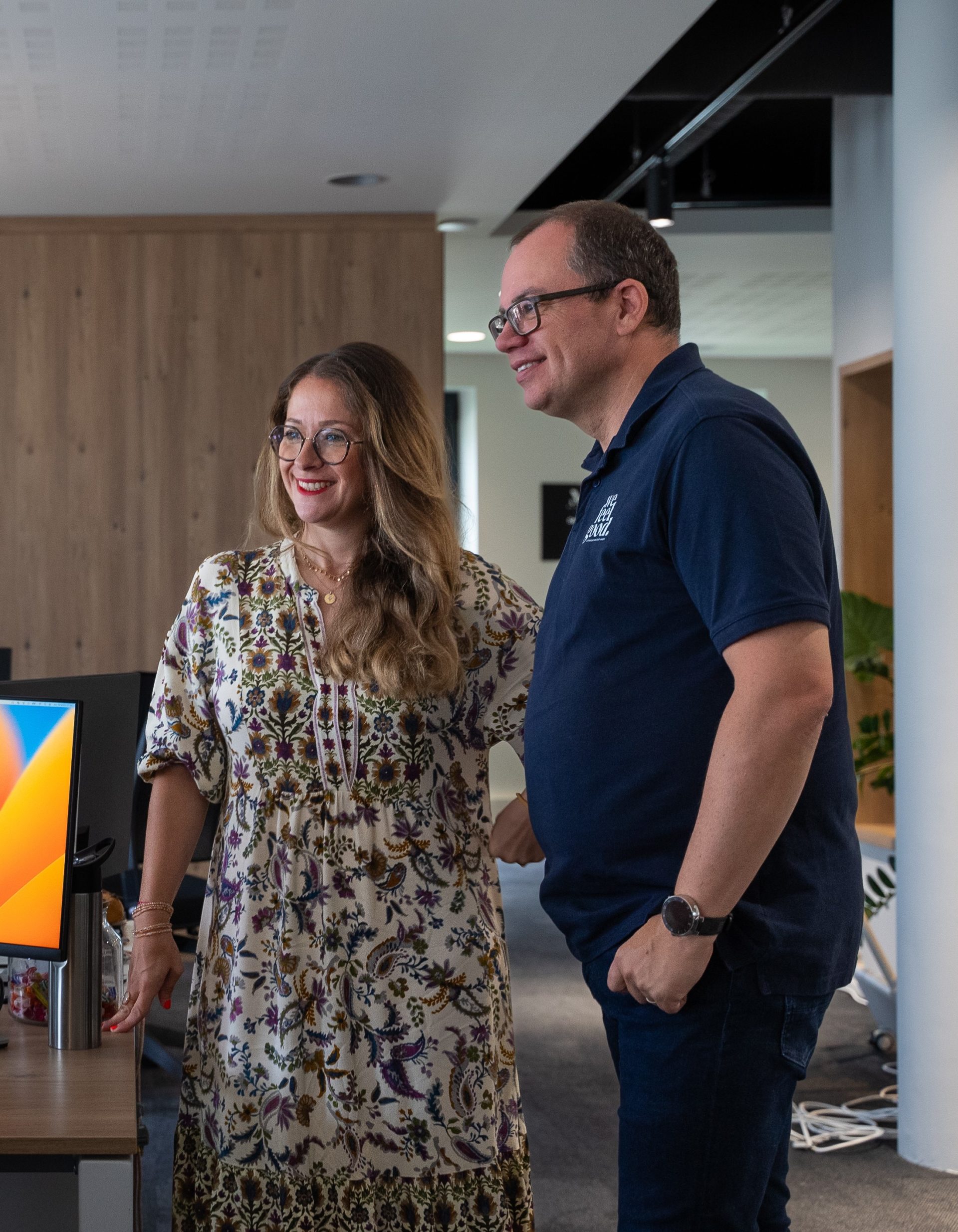 Le CEO et la directrice des expertises debout dans les bureaux de l'agence marque employeur We Feel Good